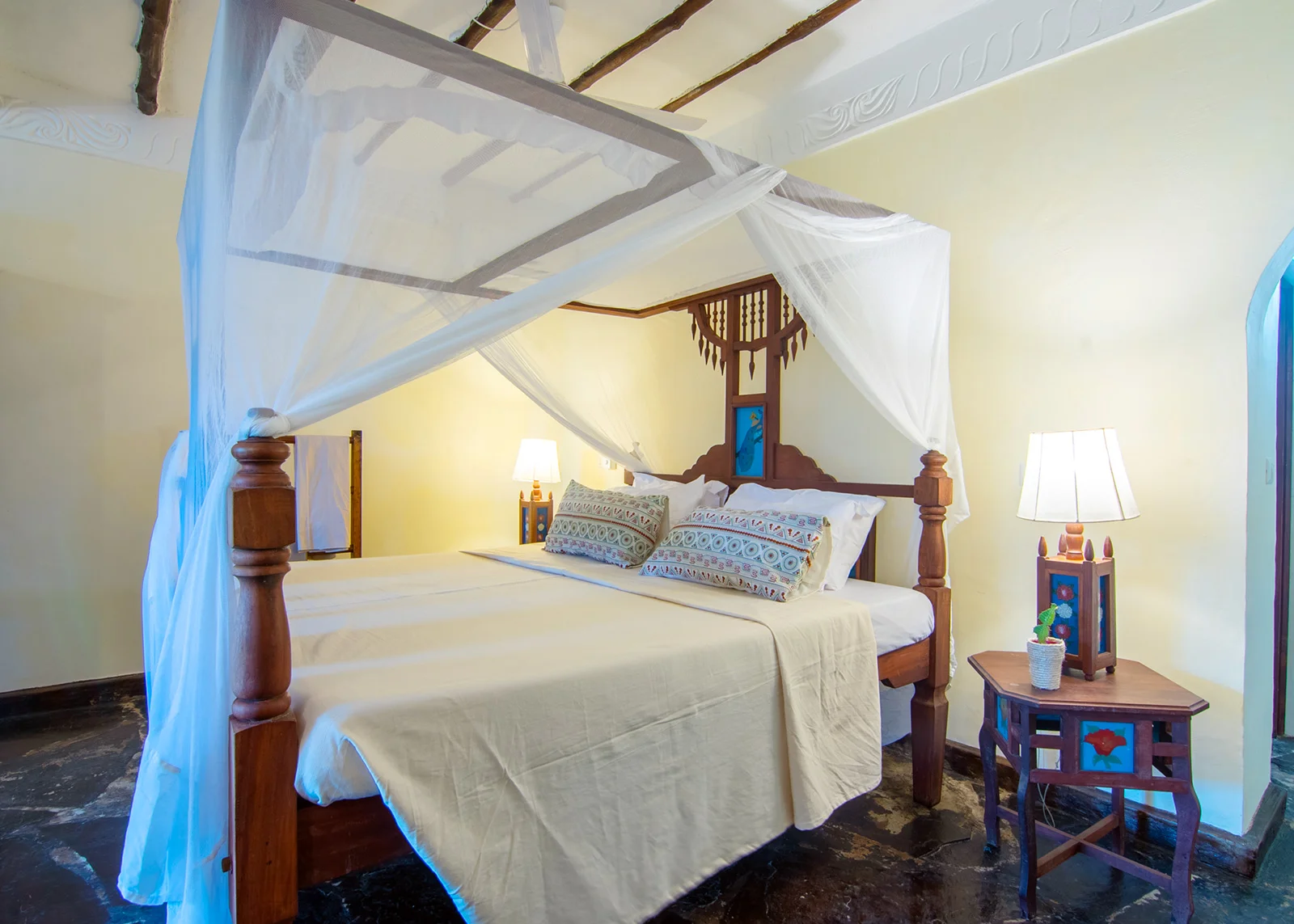 Standard Room — letto con zanzariera e arredi locali